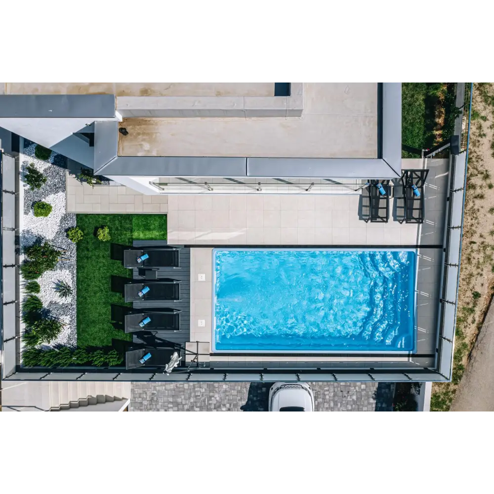 Blå rektangulär glasfiberpool Aruba med kaklad omgivning och klart vatten