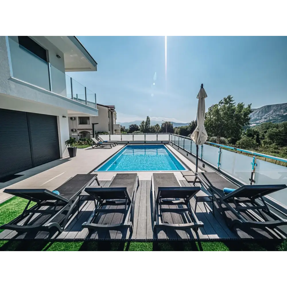 Blå rektangulär glasfiberpool Aruba med klart vatten och glasräcke