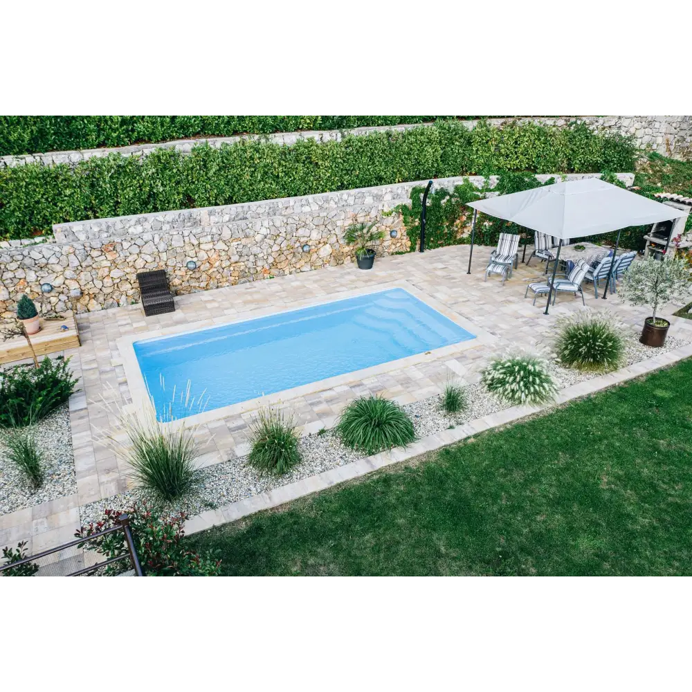 Rektangulär glasfiberpool Aruba Plus med klart blått vatten och grön kant