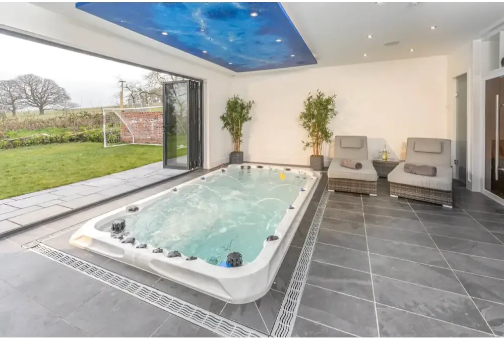 Vit PassionSpa Activity 2 Deep Swim Spa – Sport Collection, vit rektangulär med svarta jetstrålar och turkost vatten