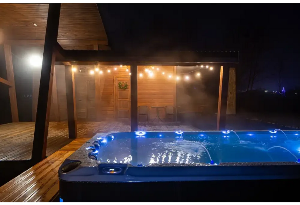Blå upplyst PassionSpa Activity 2 Swim Spa med jetstrålar och grå texturerad yta