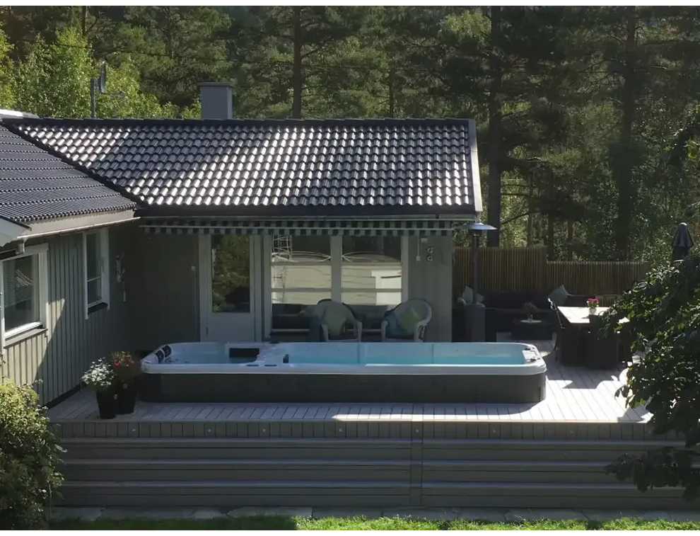 Grå PassionSpa Aquatic 3 Deep Swim Spa med blåvatten på trädäck
