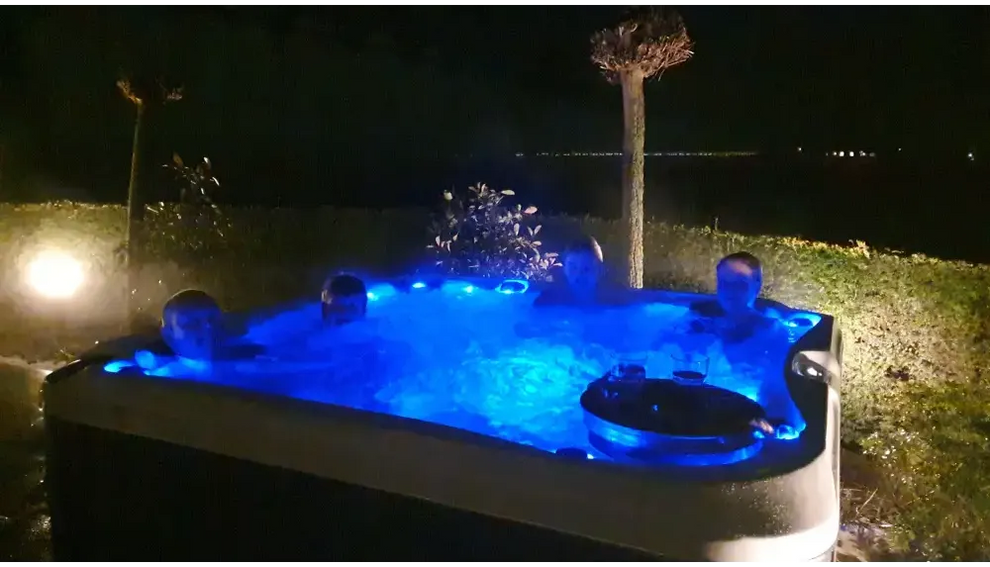 Blåljusen PassionSpa Delight Spabad med avkopplande personer på natten