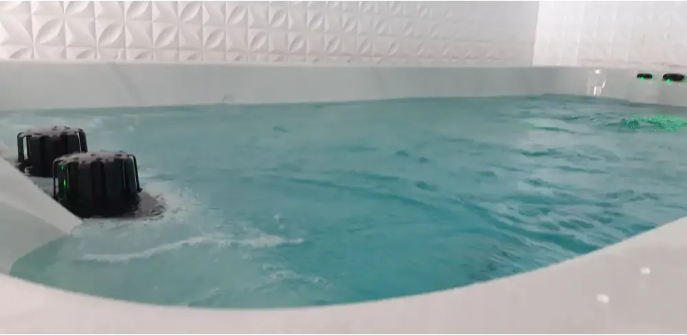 Vitvarm PassionSpa Dynamic Swim Spa med turkos vatten och svarta munstycken