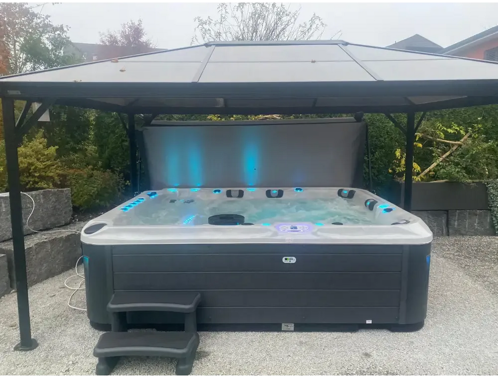 Svart och grå PassionSpa Ecstatic Mighty Wave med blå LED-belysning under tak