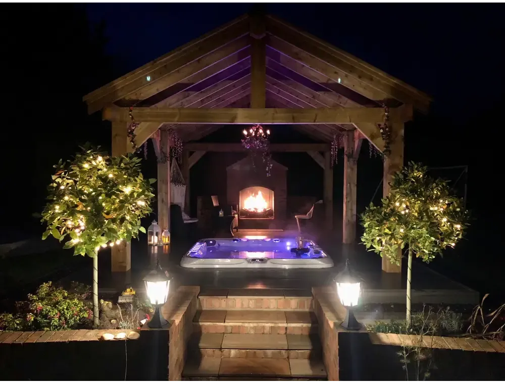 Blåupplyst PassionSpa Excite Mighty Wave spabad under trätak på natten