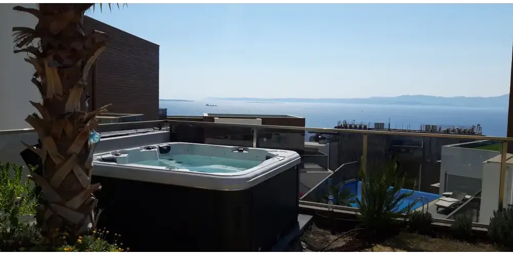 PassionSpa Relax Spabad Pure Collection svart med blåvatten på takterrass mot hav