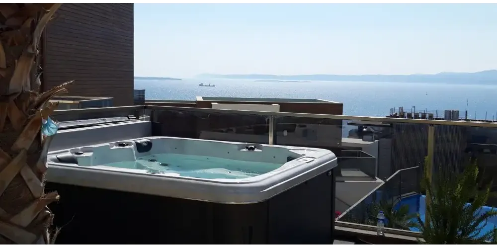 Vit och svart PassionSpa Relax Spabad Pure Collection på balkong med havsutsikt