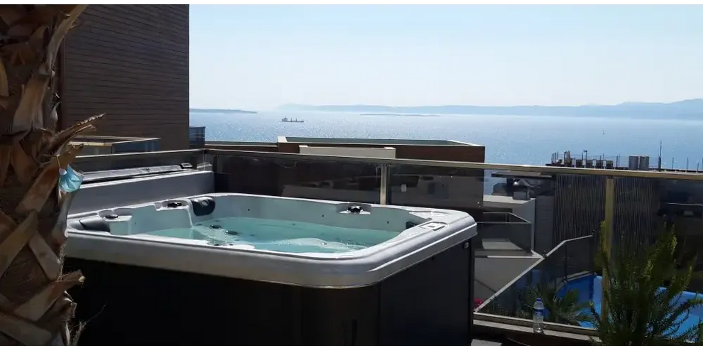 Vit och svart PassionSpa Relax Spabad Pure Collection på balkong med havsutsikt