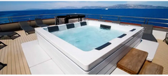 PassionSpa Serene 6 Fire Pit-spabad – hvit overflate, rektangulær form, svarte paneler, klart blått vann, treterrasse