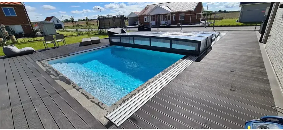Pooltaket Icon med sarg klarplast antracit, rektangulär med klarblått vatten och modern svart ram på mörkgrå trädeck