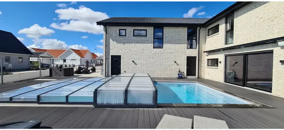 Modern vit tegelhus med svart tak och stort pooltak Icon med sarg klarplast i antracit