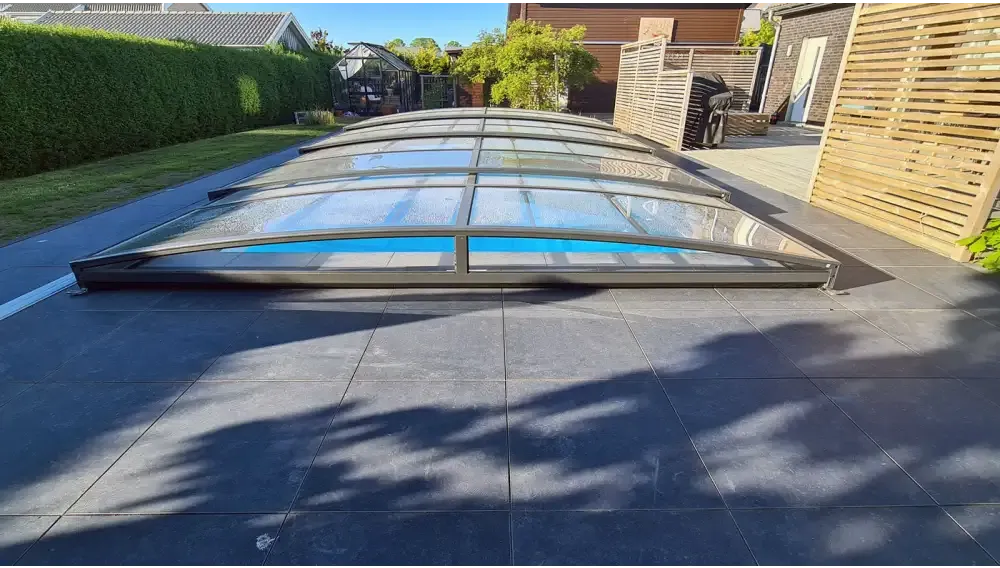 Elegant pooltak Sydney med modern valvformad glasöverdrag i svart metall för flexibilitet och poolskydd