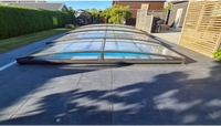 Elegant pooltak Sydney med modern valvformad glasöverdrag i svart metall för flexibilitet och poolskydd