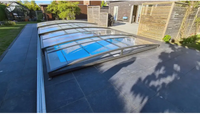 Funktionellt pooltak Sydney med modern böjd glas och svart ram för pool