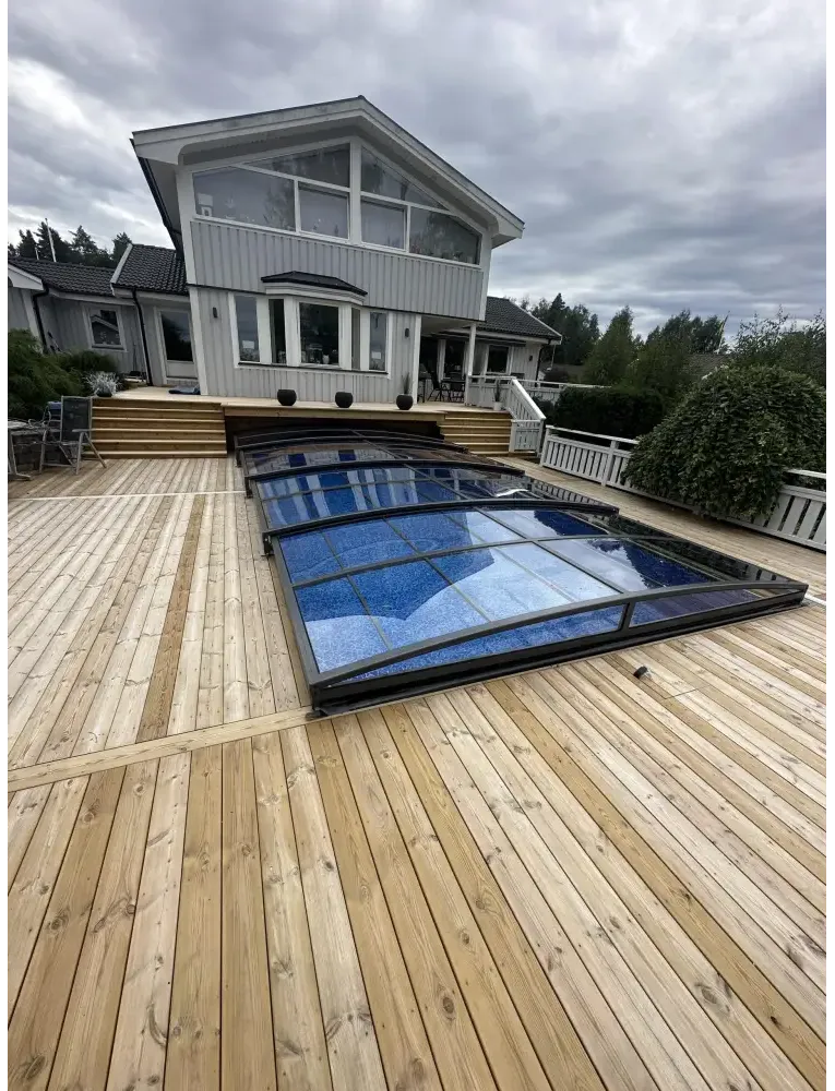 Elegant funktionellt pooltak Sydney med blå glas och svart ram på trädeck