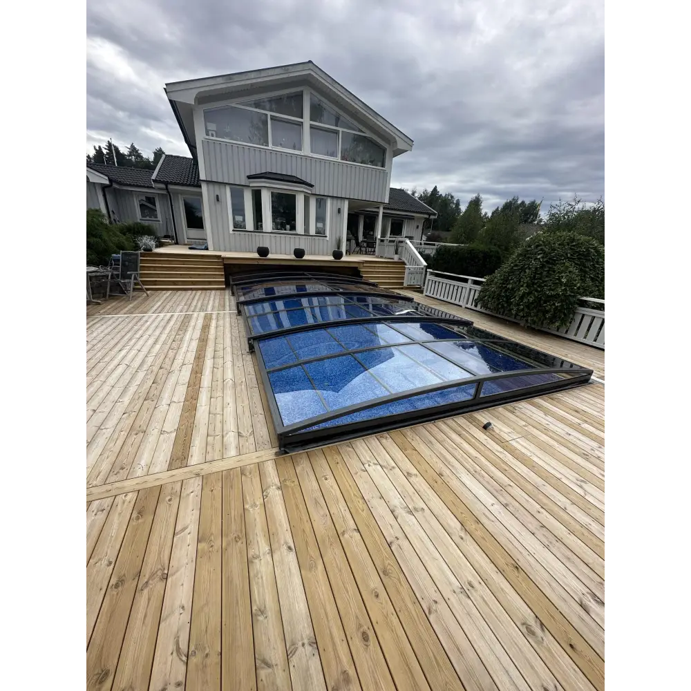 Blått glas pooltak Sydney med slank metallram på trädeck