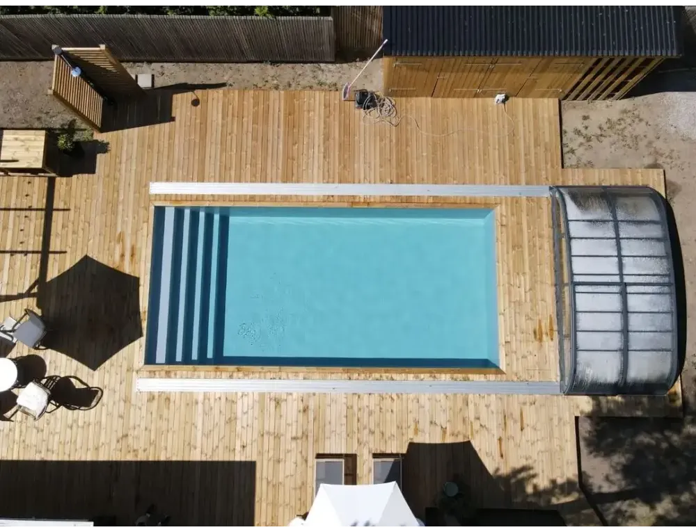 Pooltime Exklusiv 12mm rektangulär pool med turkost vatten och vit kant på trädeck
