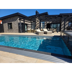 Pooltime Exclusive PP-basseng, 12 mm – 4 x 12 x 1,5 m, rektangulær form, klart blått vann, mørkegrå fliskanter, moderne steinhus