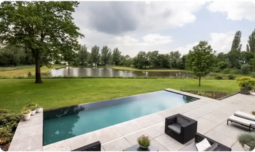 Exklusiv infinity pool med turkost vatten och svart kakel