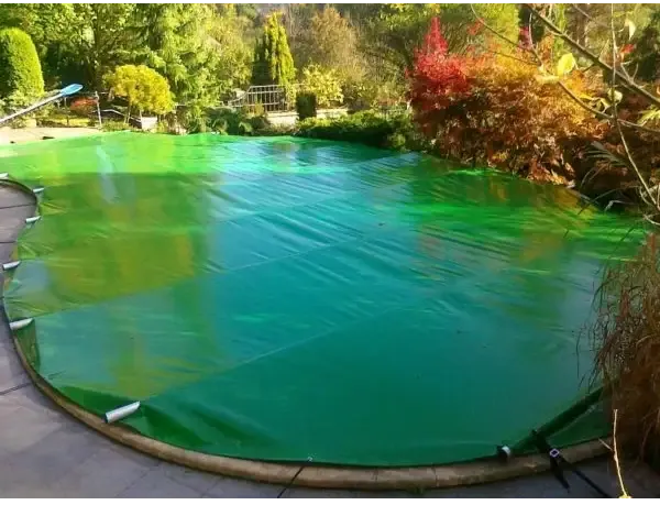 Grön pooltäckning med handhållen enhet, translucent yta och vita klämmor