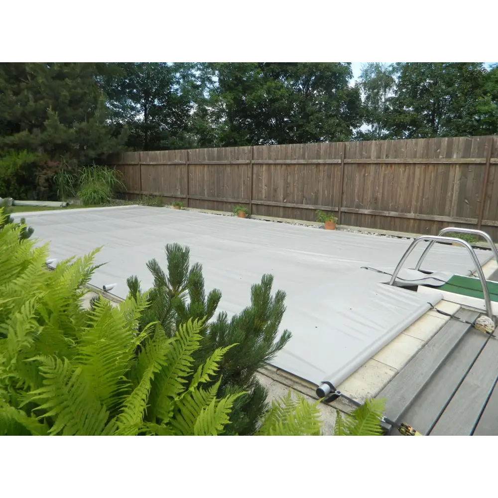 Grå pool inkl handenhet med metallram och gröna växter i förgrunden