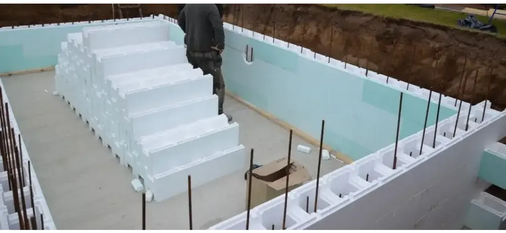Vit skumisolering i trappform vid Thermopool Standard med blå mosaik